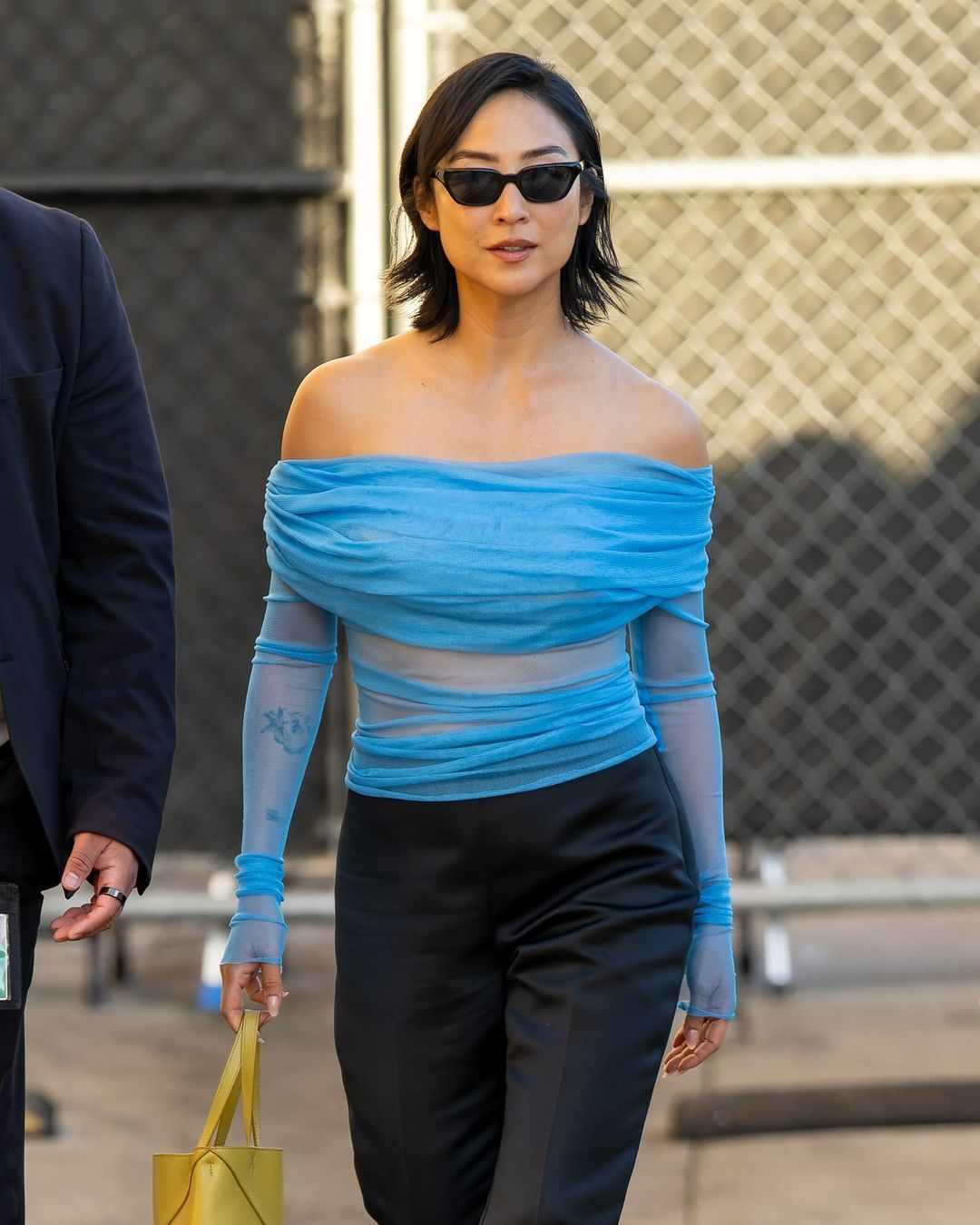 Грета Лий носи син топ и черни слънчеви очила навън