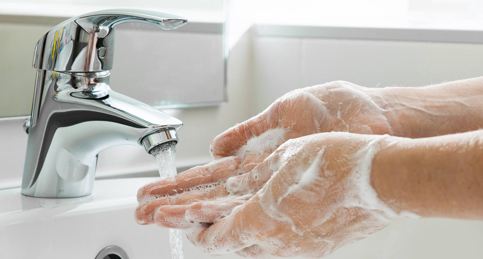 измиване на сапунени ръце под крана на мивката