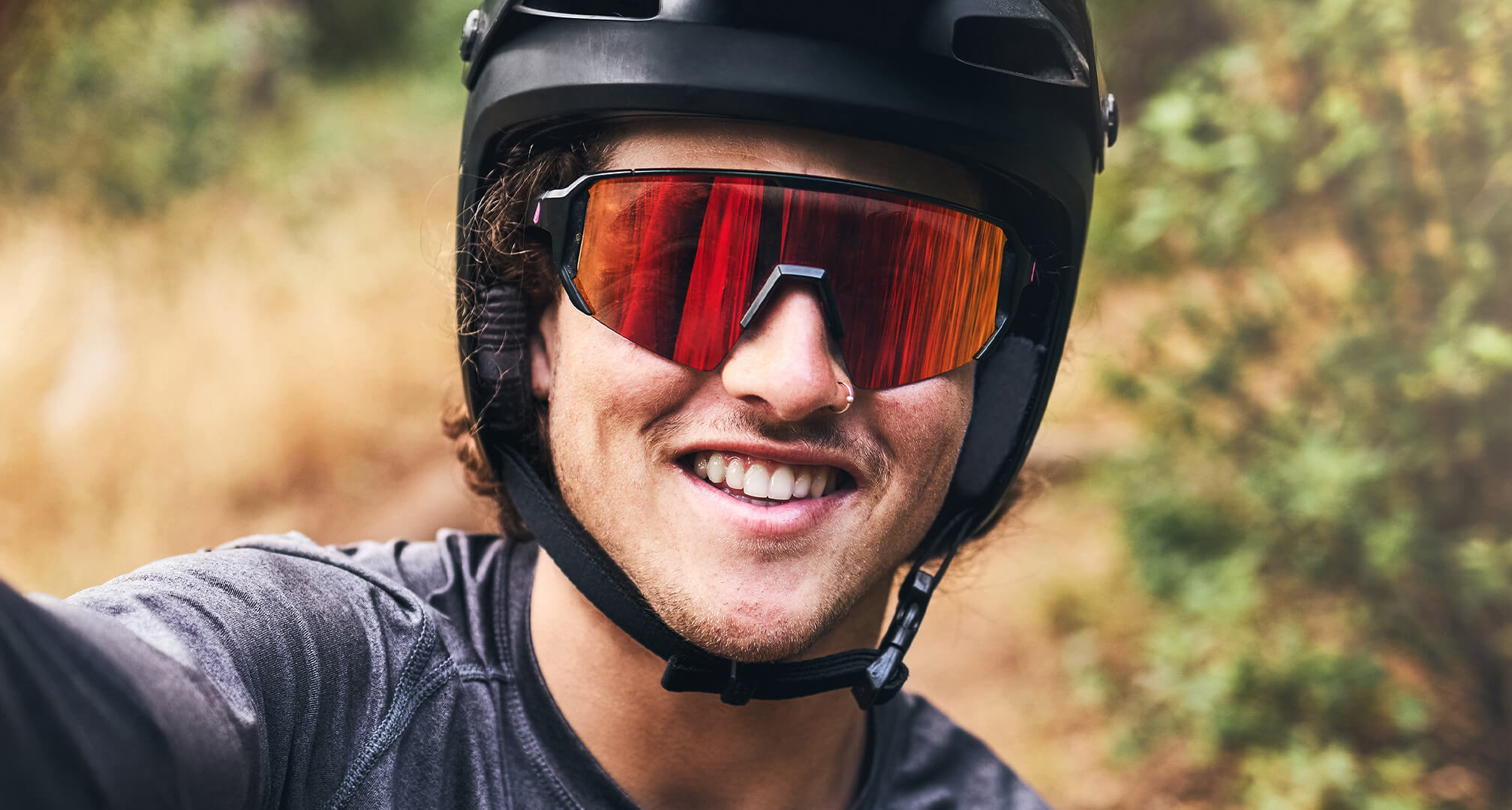 изображение в близък план на човек, носещ велосипедна каска и слънчеви очила